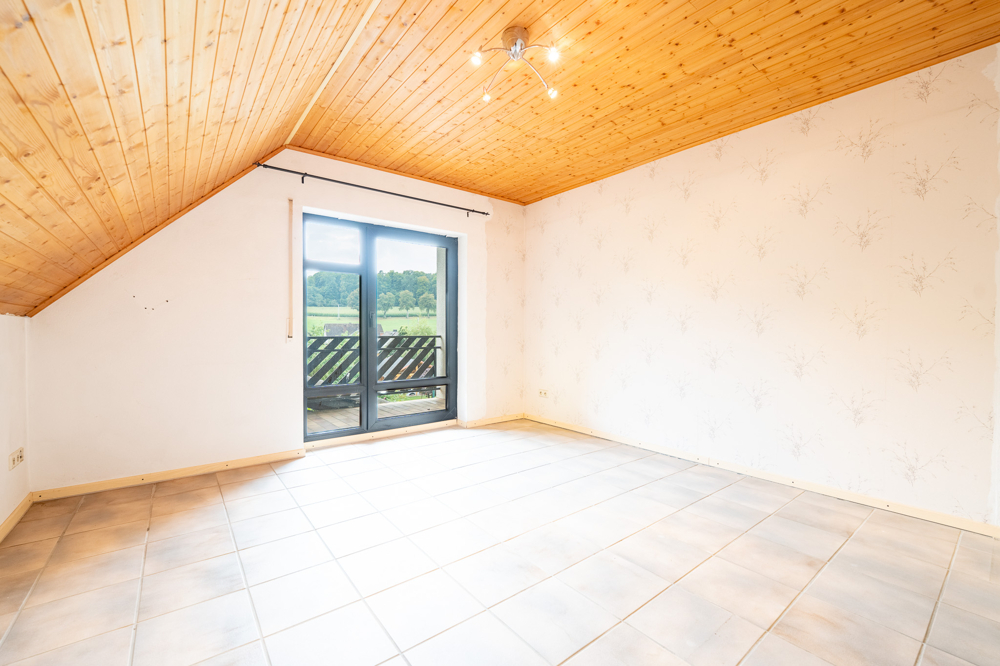 Schlafzimmer mit Balkonzugang im Dachgeschoss